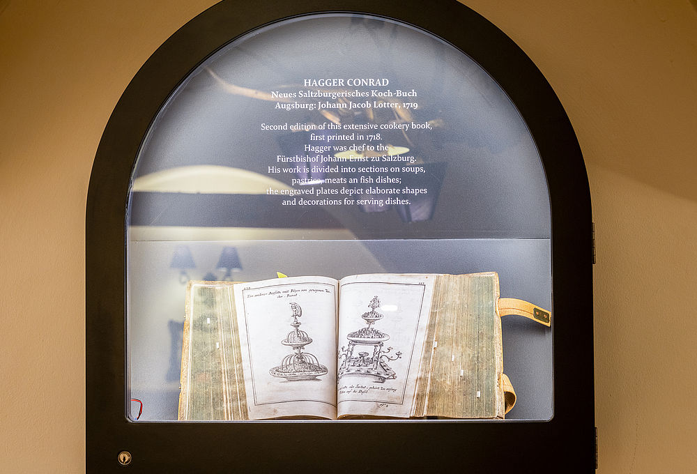 Ein antiques Salzburgerisches Kochbuch ist in einer Glasvitrine ausgestellt