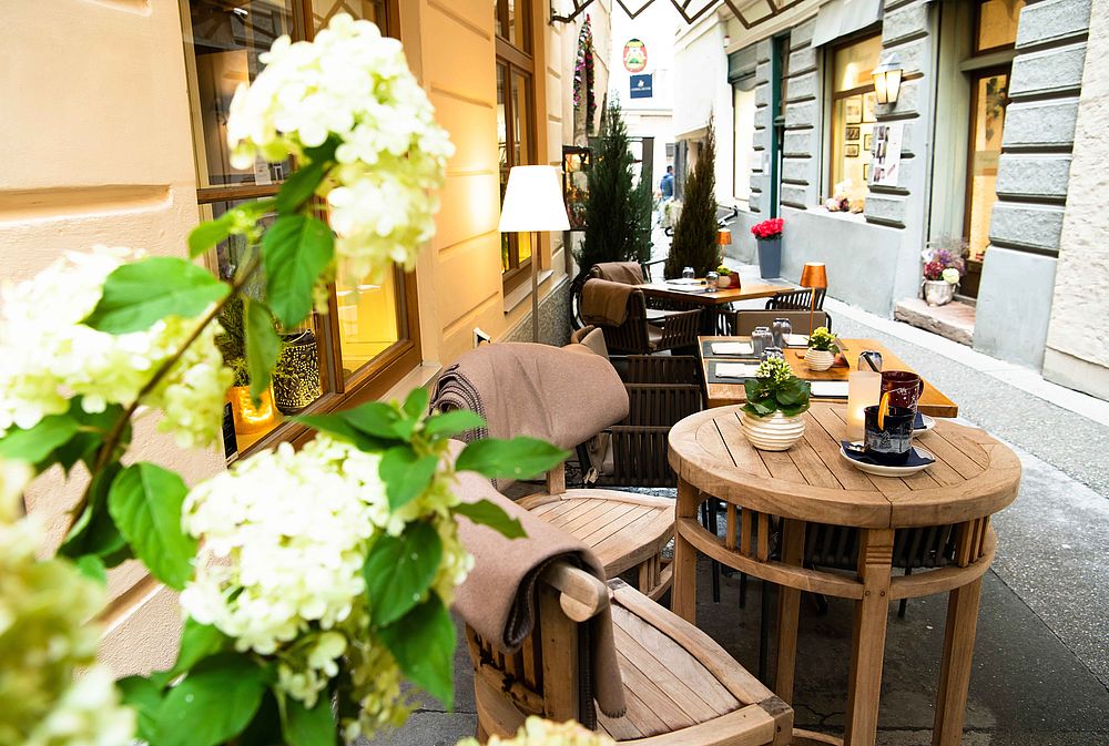 Romantische Gasse mit gemütlich gedeckten Tischen aus Holz im Hotel Goldgasse 